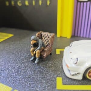 Figura de Resina 1/64: Akira Nakai (RWB) Sentado inclinado hacia delante en Sofá – Pintada a Mano